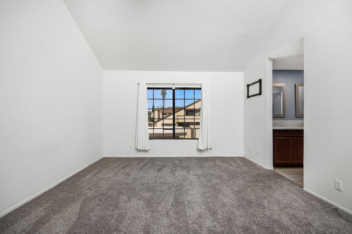 Original carpeted living room with a window wall